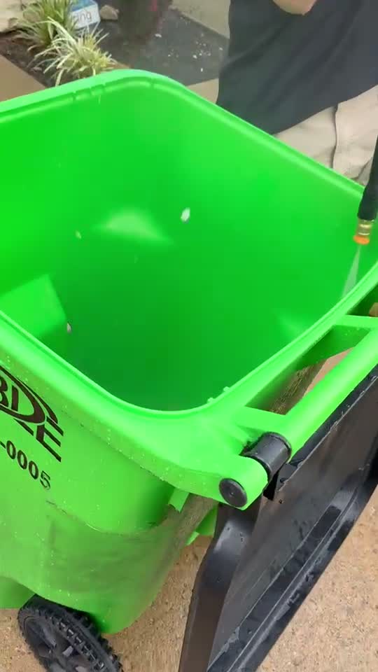 Lake Side Wash pressure rinsing a green trash bin until clean